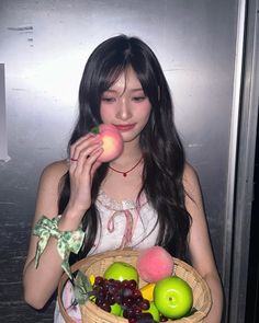 a woman holding a basket filled with fruit