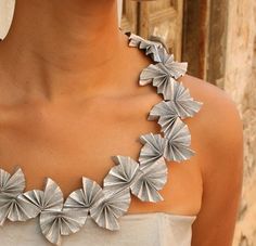 a woman wearing a silver necklace with flowers on it