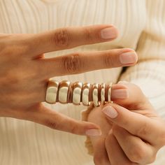 a woman is holding several rings in her hands and she has one ring on the other hand