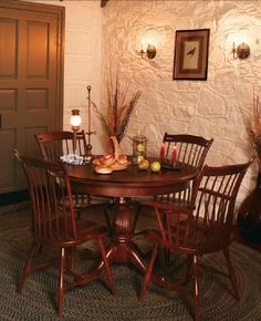 a wooden table with four chairs around it in a living room area next to a door