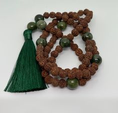 At JapamalaAU, we take great care in selecting and crafting each necklace by hand, with a deep commitment to ensuring your utmost satisfaction and enjoyment. This mala has 9 sections, each section is made up of 12 smaller beads and the 13th being a larger counter bead. A Rudraksha and green jade mala is a traditional prayer necklace consisting of beads made from Rudraksha seeds and green jade stones. In Hinduism and Buddhism, malas are used for prayer and meditation, with each bead representing Handmade Green Traditional Mala, Green Polished Beads Mala For Gift, Rudraksh Mala, Jade Mala, Green Hand-strung Spiritual Mala, Spiritual Hand-strung Jade Beaded Necklace, Kriya Yoga, Rudraksha Beads, Yoga Necklace