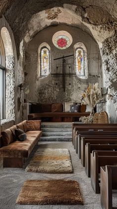 the interior of an old church with stained glass windows and pews on either side