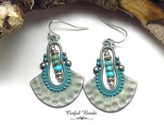 Make a statement with these boho earrings, showcasing turquoise Imperial Jasper rondelle beads nestled inside intricate silver tribal pendants with a turquoise patina wash. The intricate design and vibrant colors make them a perfect accessory for any outfit. Complete your look by picking your favorite earwires from a selection of 6 options. These earrings are sure to turn heads. 𝐋𝐄𝐍𝐆𝐓𝐇: 1 7/8" with hook earwires. Kidney wires will add about 1". 𝐖𝐈𝐃𝐓𝐇: 1 1/8" 𝐖𝐄𝐈𝐆𝐇𝐓: 3.30 grams. A nickel weighs 5 grams. All jewelry is packaged ready for gift giving. Each item comes in an organza bag and packaged in a cotton filled kraft paper box. 𝐌𝐘 𝐎𝐓𝐇𝐄𝐑 𝐒𝐇𝐎𝐏𝐒 🔶𝐋𝐄𝐀𝐓𝐇𝐄𝐑 𝐁𝐑𝐀𝐂𝐄𝐋𝐄𝐓𝐒, 𝐄𝐀𝐑𝐑𝐈𝐍𝐆𝐒, 𝐀𝐍𝐃 𝐍𝐄𝐂𝐊𝐋𝐀𝐂𝐄𝐒: https://www.etsy.com/shop/CinfulBead Handmade Turquoise Metal Chandelier Earrings, Turquoise Metal Beaded Bohemian Earrings, Handmade Turquoise Beaded Metal Earrings, Turquoise Beaded Earrings With Metal Ear Wire, Handmade Turquoise Beaded Earrings, Turquoise Metal Beaded Dangle Earrings, Turquoise Metal Dangle Beaded Earrings, Bohemian Turquoise Beaded Nickel-free Earrings, Turquoise Beaded Dangle Earrings