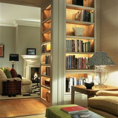 a living room filled with furniture and a fire place in the middle of it's wall