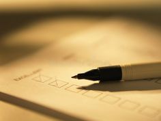 a pen sitting on top of a piece of paper next to a check mark stock photos