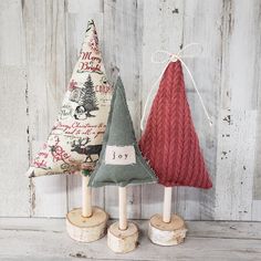 three wooden christmas trees on top of logs