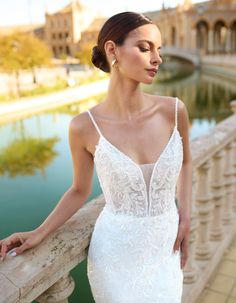 a woman in a wedding dress leaning on a railing