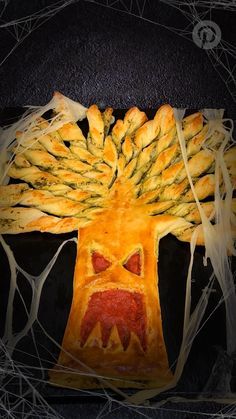 a pumpkin shaped pastry in the shape of a tree with an evil face on it