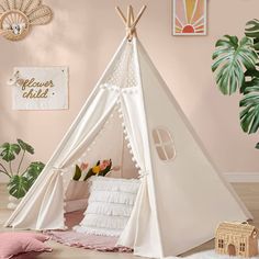 a teepee tent with pillows and blankets in the corner, next to a potted plant