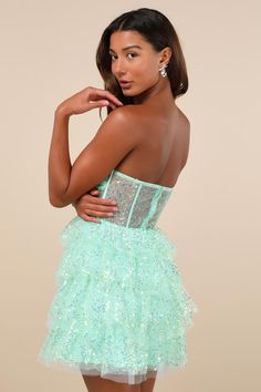 The Lulus Illustrious Glow Mint Green Sheer Tulle Sequin Tiered Mini Dress is perfect for any occasion that calls for extra extravagance! This sensational dress features a sparkling sequin design across the tulle-mesh construction that shapes a strapless, bustier-inspired bodice with sheer mesh paneling (along with supportive boning), a gathered bust with padded cups, and a sweetheart neckline with hidden no-slip strips. The high, fitted waist sits atop a fun and frilly tiered skirt that finishe Mint Green Clothes, Mint Green Outfits, Green Clothes, Sheer Clothing, Tier Dress, Strapless Bustier, Tiered Mini Dress, Tiered Ruffle Dress, Sequin Design