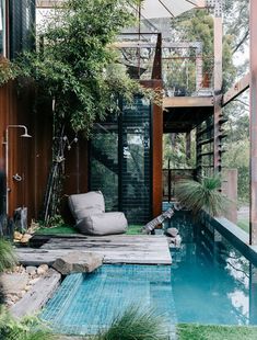 an outdoor living area with a pool and lounge chair next to the swimming pool is surrounded by greenery