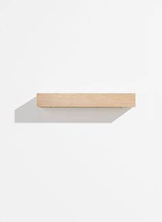 a white wall with a wooden shelf on it