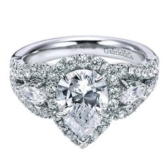 an engagement ring with three pear shaped diamonds in the center and side stones on each band