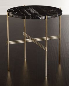 a black marble topped table with gold legs