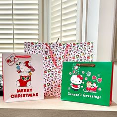 three christmas shopping bags sitting on top of a counter