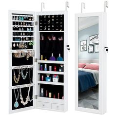 two mirrored doors with jewelry hanging on them and one door open to reveal a bed in the background