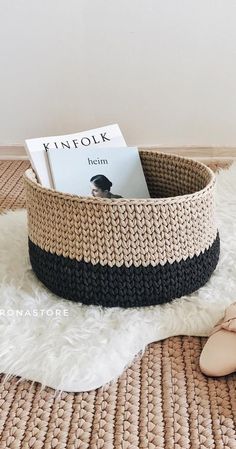 a knitted basket sitting on top of a rug next to a pair of slippers