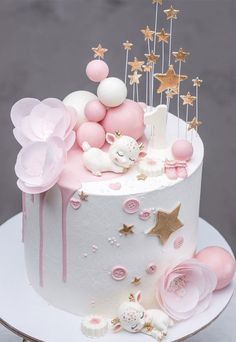 a white cake with pink and gold decorations