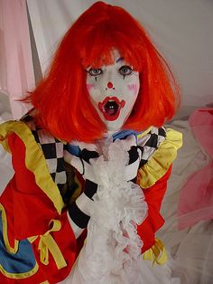 a creepy clown with red hair and makeup