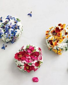 three cakes with flowers on them sitting next to each other