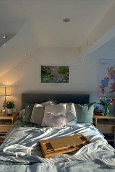 a bed sitting under a painting on top of a wooden dresser next to a lamp