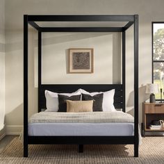 a four poster bed in a bedroom with beige walls and carpeted flooring on the side