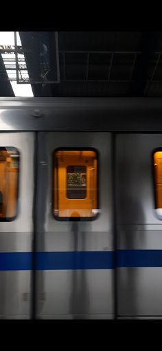 an empty subway car with three windows and no people on the platform or in the station