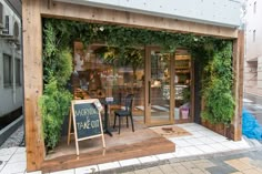 a store front with plants growing on the outside