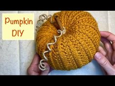 someone is holding up a pumpkin that has been crocheted