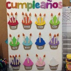 cupcakes with candles are displayed on a bulletin board