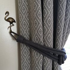 a flamingo hook on the side of a curtain in a room with white walls