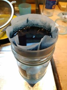 a glass filled with liquid sitting on top of a wooden table