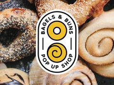 the logo for bagels and bus's pop up shop is shown in front of a pile of doughnuts