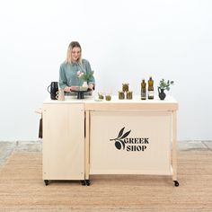 a woman standing behind a counter with bottles on it