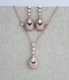 "Pretty rose gold pendant necklace so sparkly with Swarovski Pure brilliance stones ! This is available in a set or by itself. Please choose from drop down menu. Necklace measures 17 inches and extends to 19 inches Pendant portion measures 1.75\" x 5/8\" Earrings measure 1.75\" x 5/8\" Matching bracelet: https://www.etsy.com/listing/674474135/rose-gold-bridal-bracelet-teardrop?ref=shop_home_active_1&pro=1&frs=1 Back to my shop: https://www.etsy.com/shop/TheExquisiteBride?ref=l2-shopheade Rose Gold Cubic Zirconia Drop Jewelry, Rose Gold Dangle Jewelry With Sparkling Stones, Rose Gold Dangle Jewelry Sets With Matching Earrings, Rose Gold Dangle Necklaces With Matching Earrings, Rose Gold Statement Necklace, Rose Gold Earrings Wedding, Crystal Wedding Necklace, Rose Gold Drop Earrings, Rose Gold Wedding Jewelry