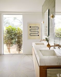 a bathroom with two sinks and a large glass door leading to an outside patio area