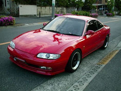 a red sports car parked on the side of the road