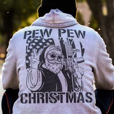 a man riding on the back of a motorcycle wearing a shirt that says pew pew christmas