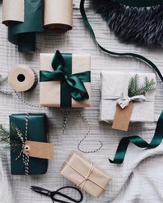 presents wrapped in brown paper and tied with green ribbon on top of a white blanket