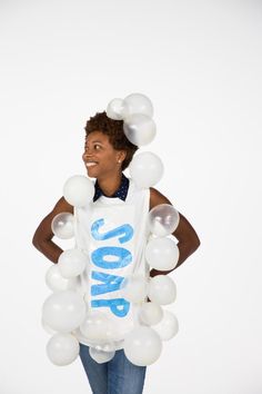 a woman standing with balloons in her hands and wearing a shirt that says love on it