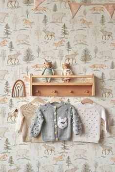 a baby's room with deer wallpaper and teddy bears hanging on the wall