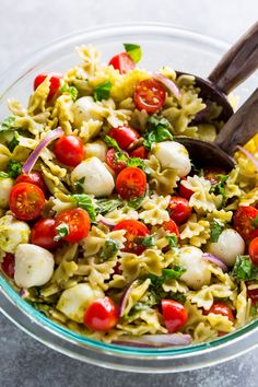 pasta salad with tomatoes, mozzarella and basil in a glass bowl