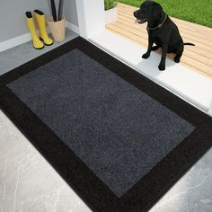 a black dog sitting on top of a rug next to a wooden bench and yellow boots