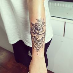 a woman's arm with a rose tattoo on the left side of her arm