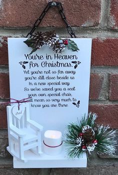 a white sign hanging on the side of a brick wall next to a lit candle