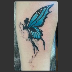 a blue butterfly tattoo with stars on it's legs and the shape of a woman's body