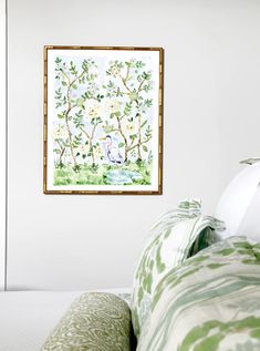 a painting hanging on the wall above a bed in a room with green and white decor