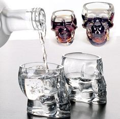 three shot glasses filled with liquid being poured into them