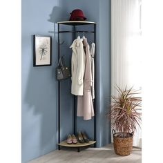 a coat rack with shoes and purses hanging on the wall next to a potted plant