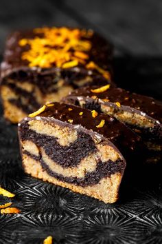 slices of chocolate orange swirl cake on a black tablecloth with yellow and white sprinkles